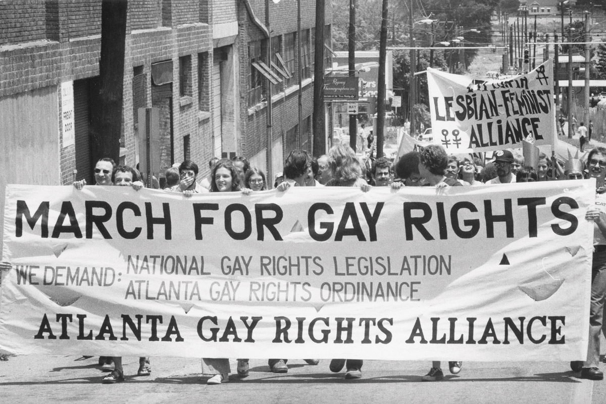 Protesters march in downtown Atlanta holding a "March for gay rights" sign