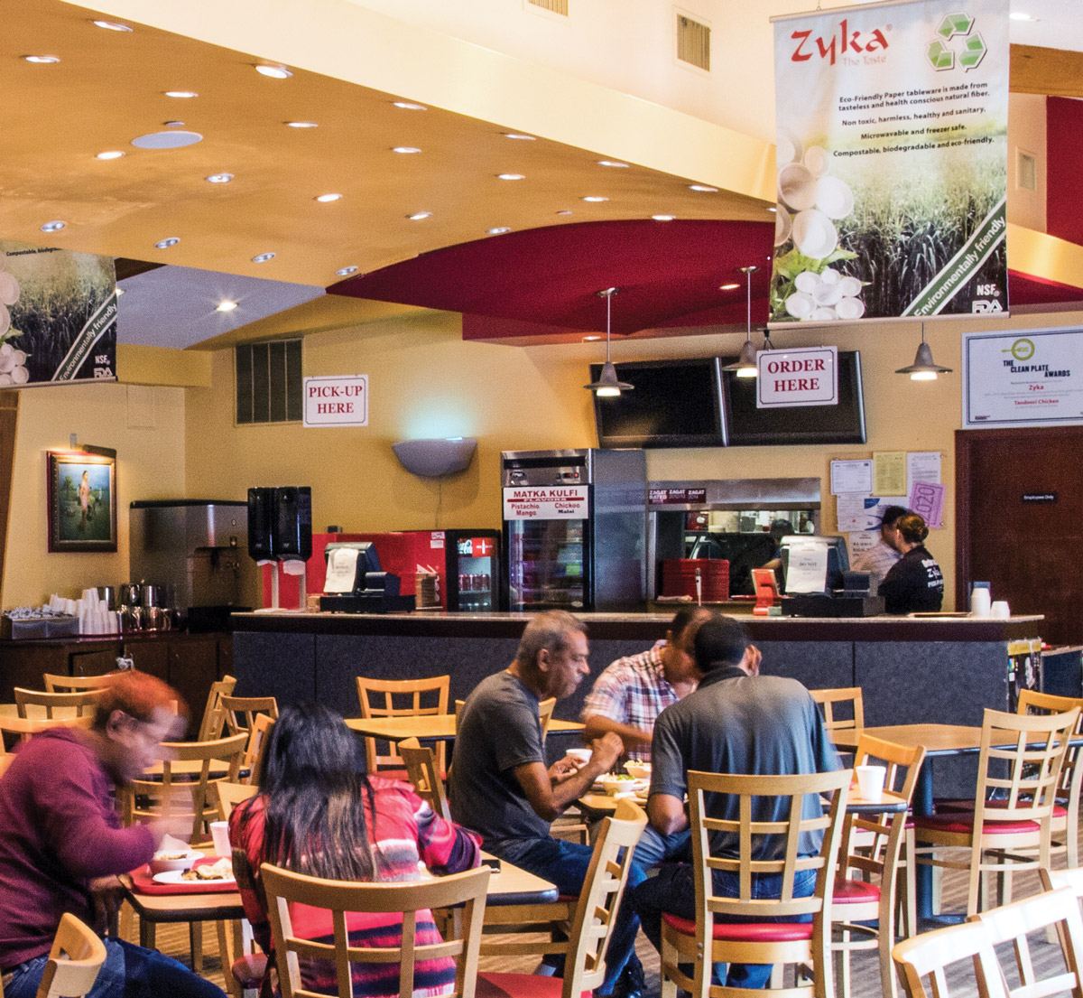 People eating at wooden tables in Zyka