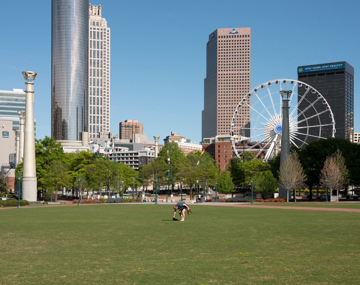 A man gathers his belongings in an empty Centennial Olympic Park on a Saturday afternoon.