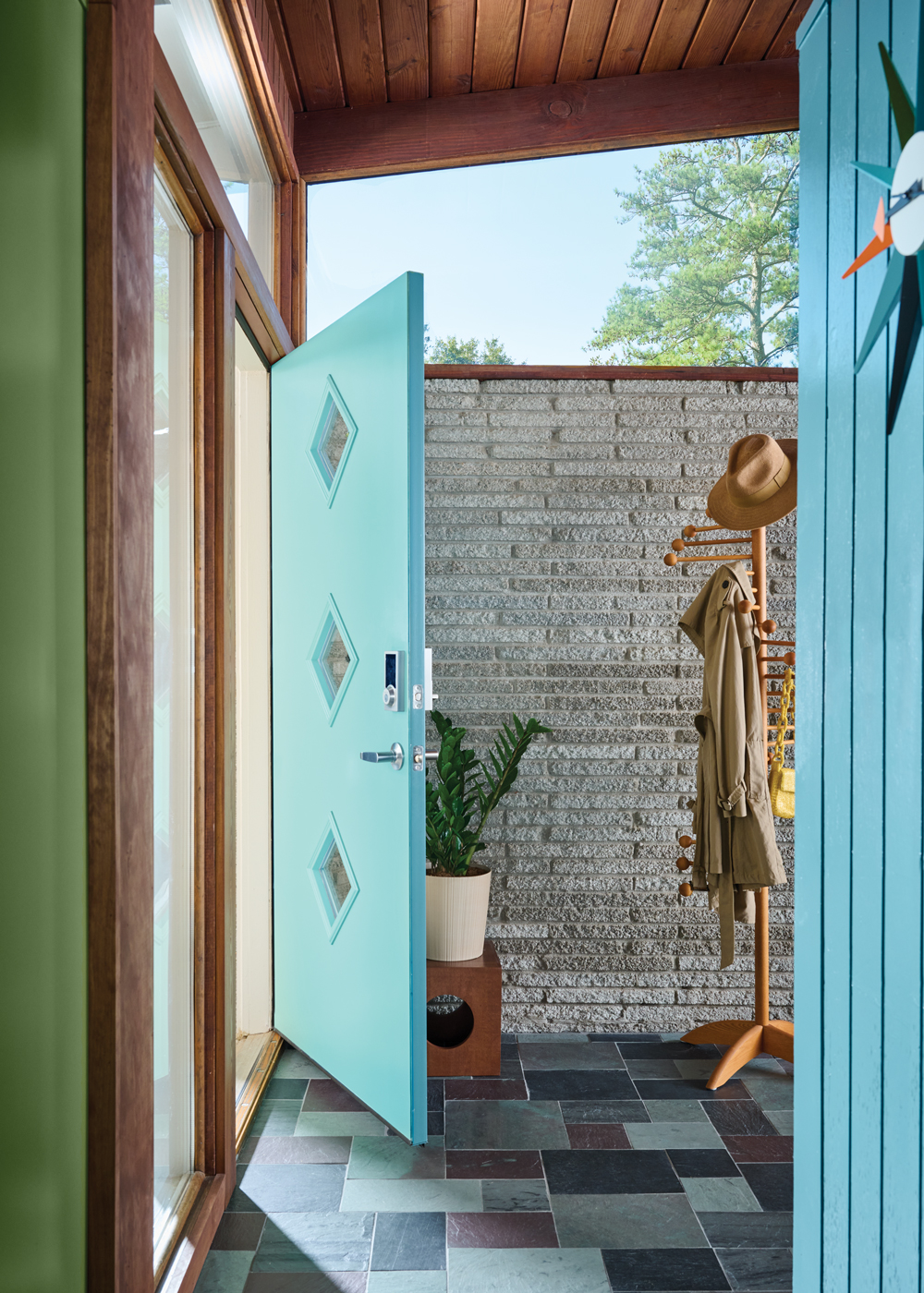 The new turquoise front door features diamond windows as a geometric detail. Michaela Quinton of Copper Sky Design & Remodel says, 