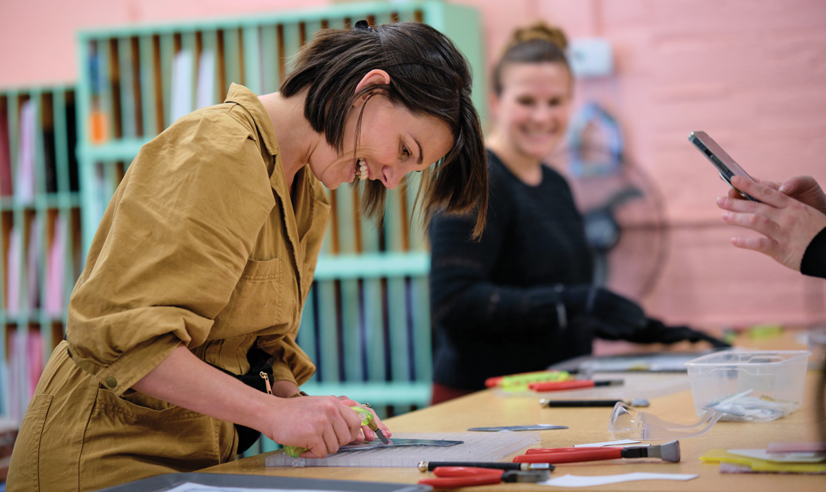 A student in a stained glass workshop