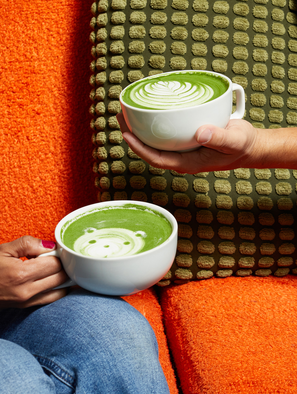 Matcha lattes with a flower and a bear painted on top