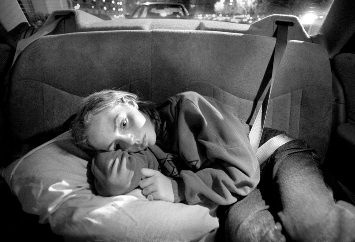 Amanda, laying on a pillow in the back seat of a car