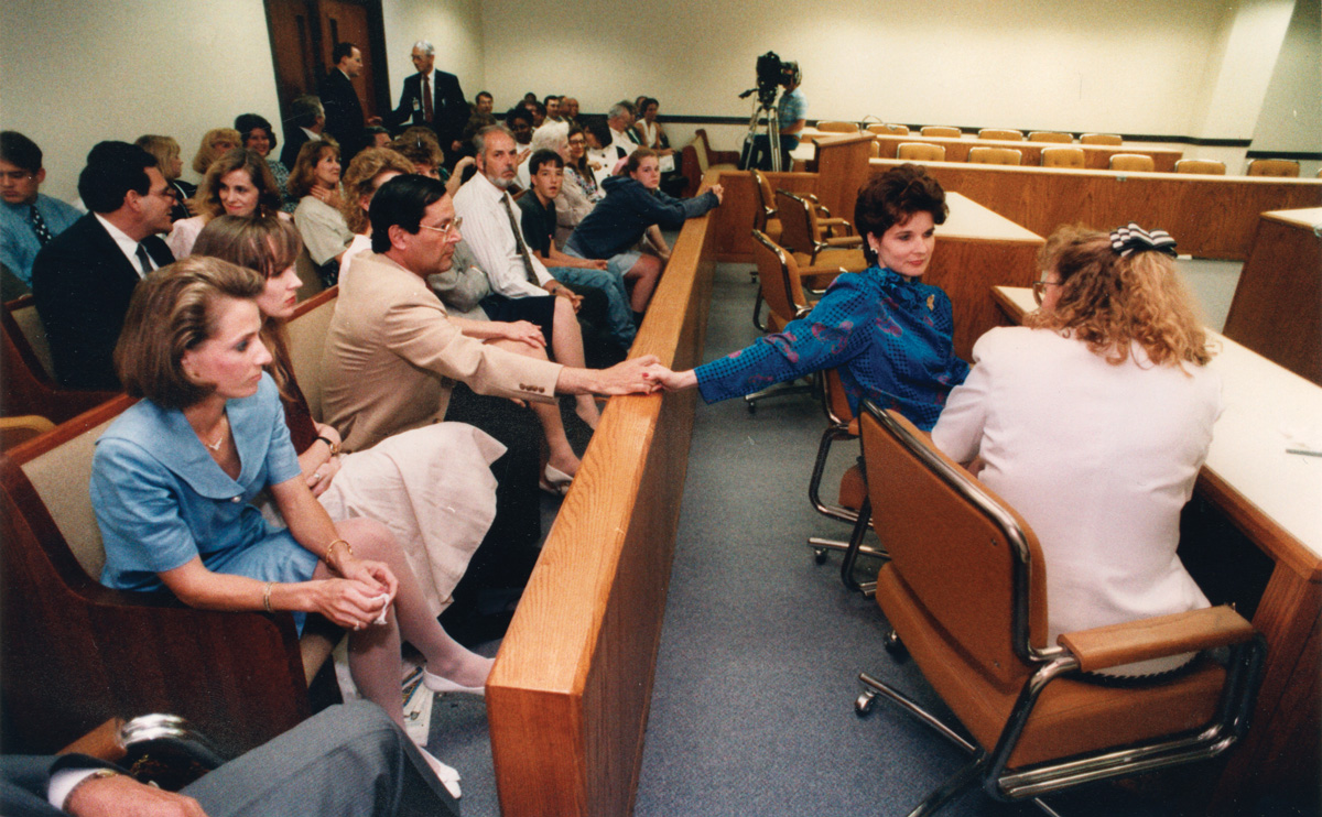 Yager holding hands with her husband, Howard, in the court room