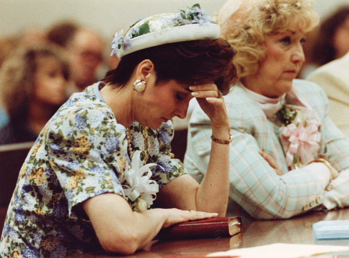 Faye Yager holding her head in her hand in the court room