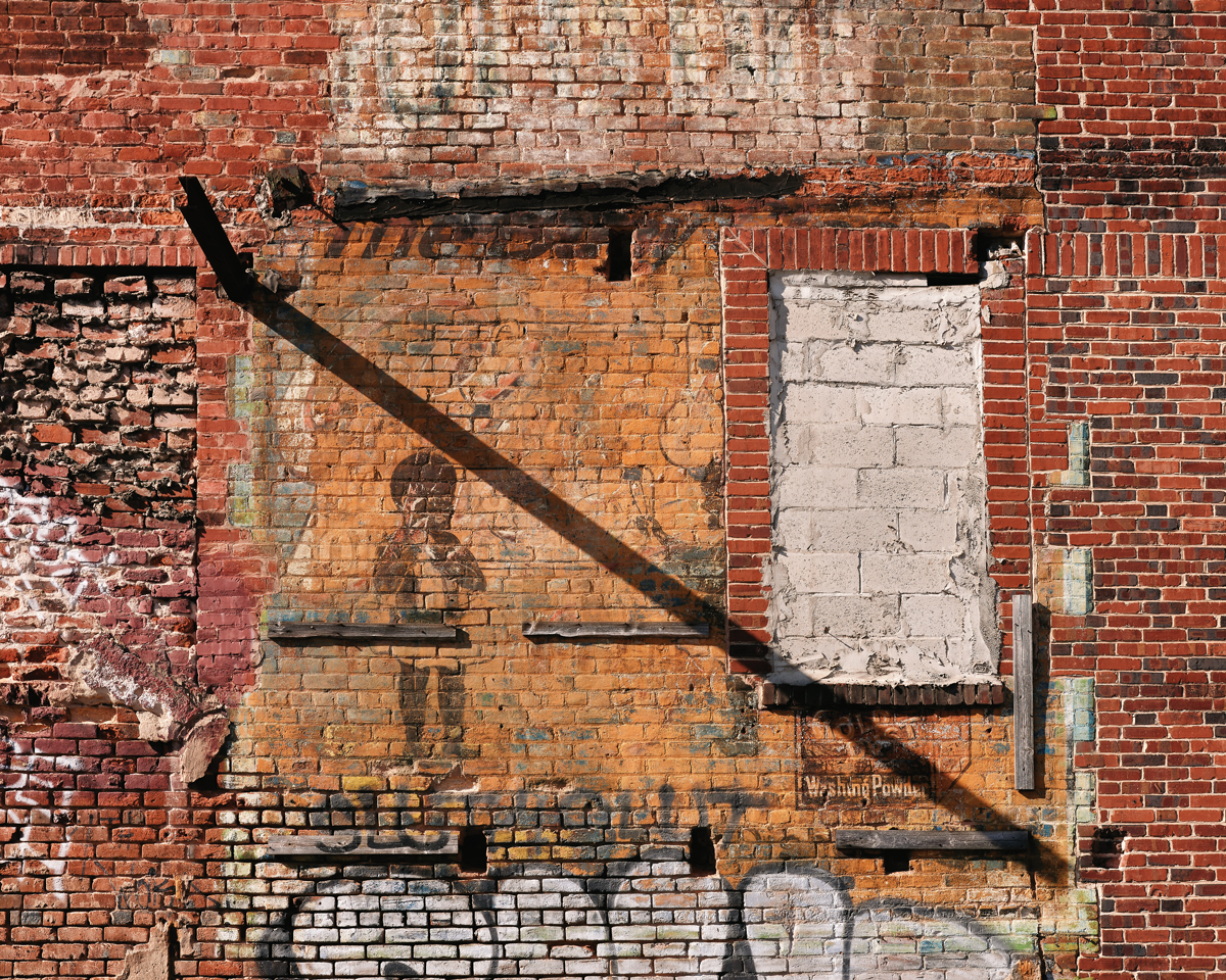 A faded 20th-century advertisement, revealed after a tornado, is a visual reminder of Atlanta’s complicated past