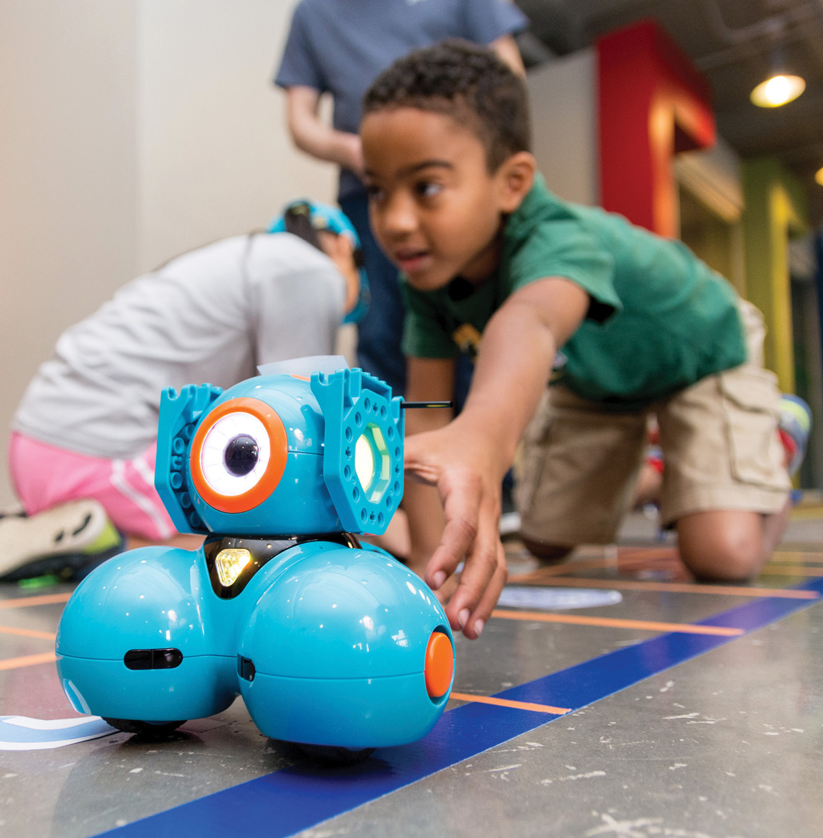 A kid learning how to program a robot