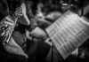 A flute player reading sheet music in an orchestra