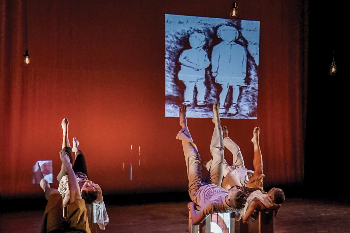 Five dancers laying down and kicking their feet in the air