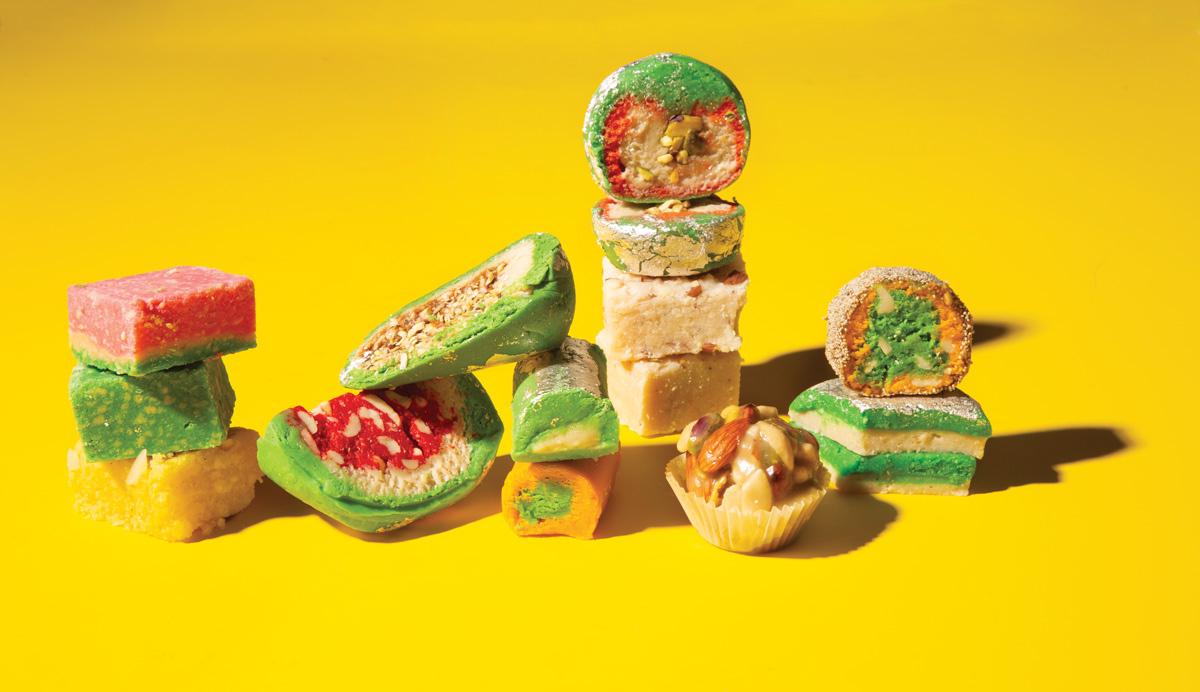 Assorted Indian delicacies from Gokul Sweets on a yellow background