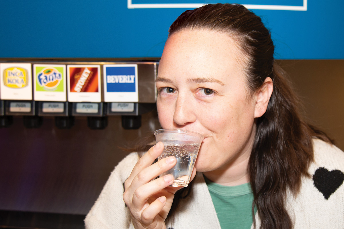 Author Caroline Eubanks sips a cup of Beverly flavored soda