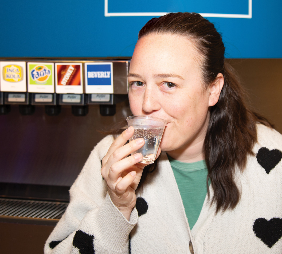 Author Caroline Eubanks sips a cup of Beverly flavored soda