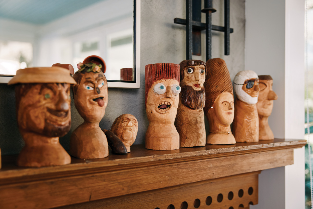 A series of uniquely carved wooden busts stand atop the fireplace