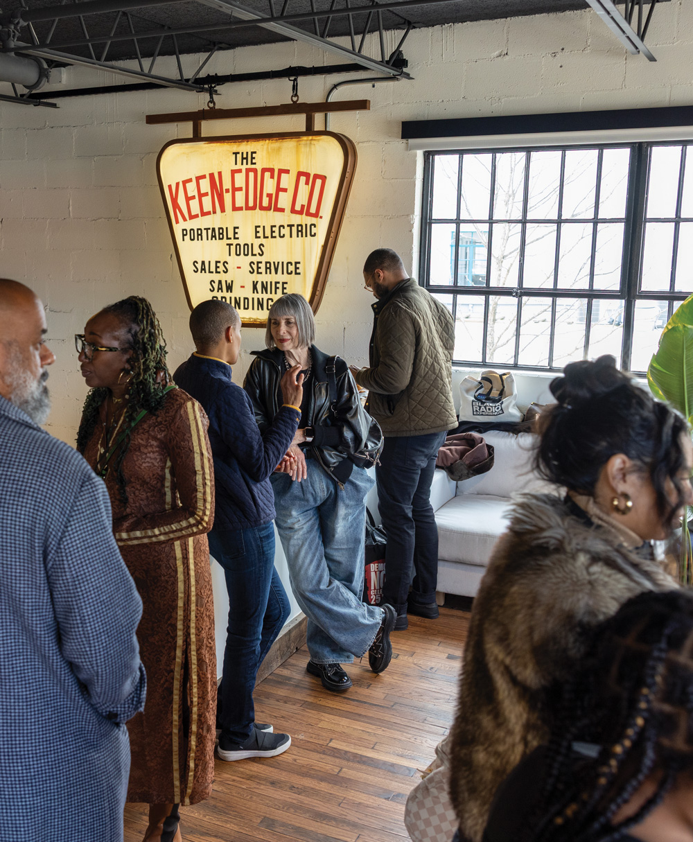 Attendees stand in conversation with each other beside a big