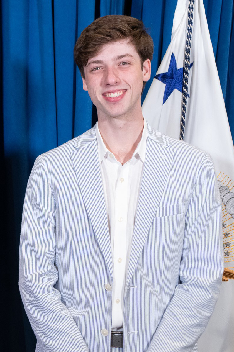 Parker Short smiling while wearing a blue pinstripe suit