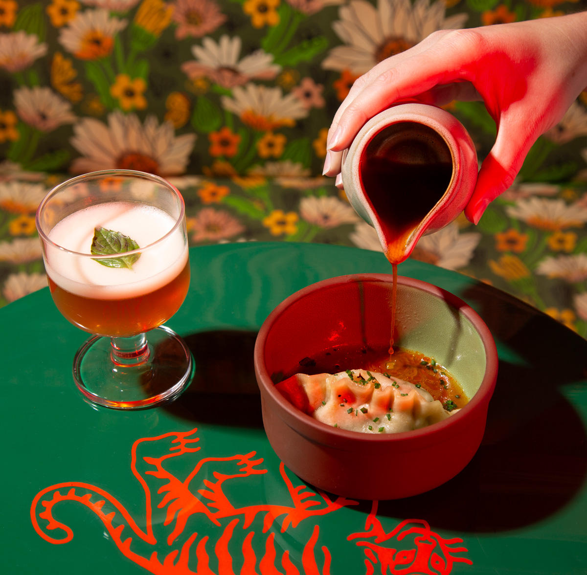sauce being poured onto a dumpling at a Tiger Sun table