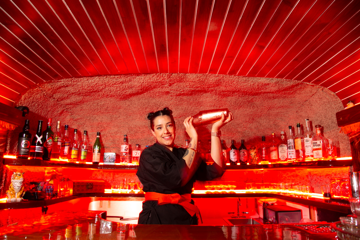 a bartender shakes a cocktail behind the Tiger Sun bar