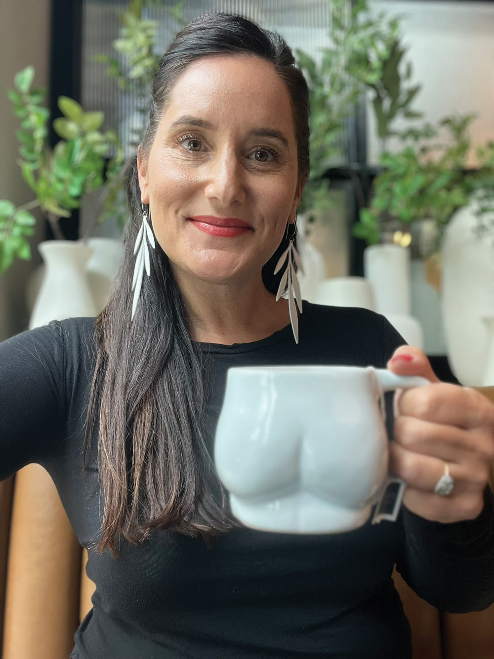 Molly Sanyour at her studio with one of her butt mugs in hand