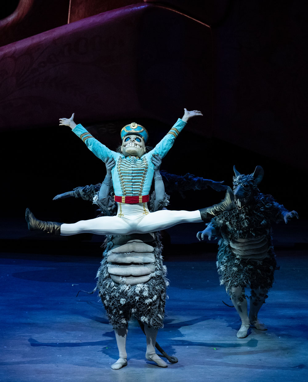 The nutcracker being picked up in the air doing a middle split