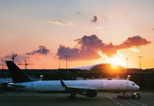 A love letter to the Atlanta airport an airplane sits still in front of the orange sunset