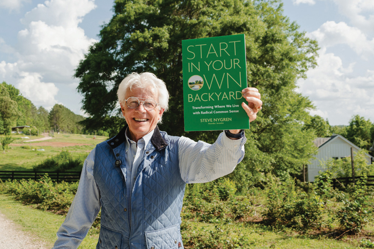 Steve Nygren proudly holds up his book about making change at a local level