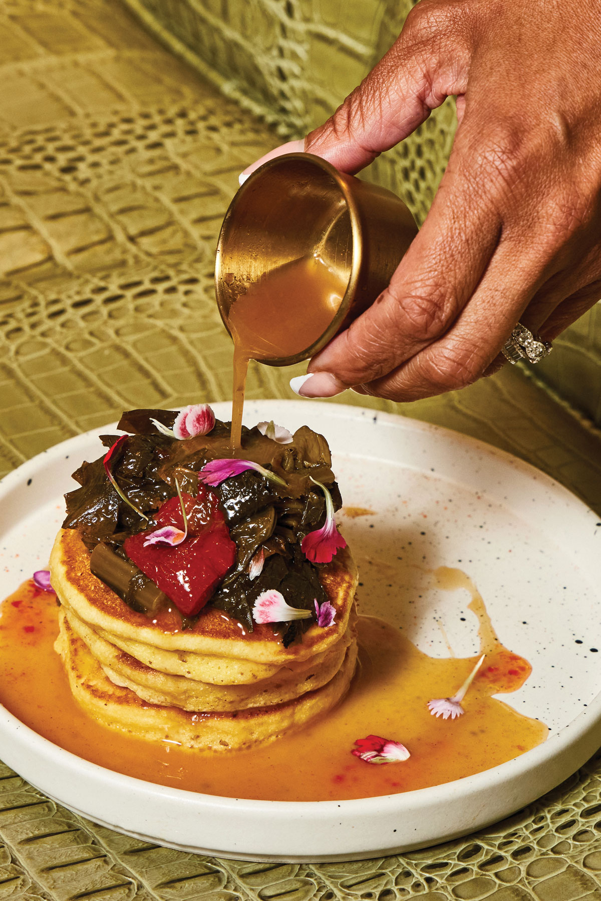 A person pours sauce on hoe cakes and potlicker