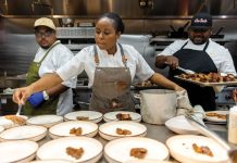 Chryss Lewis plates chicken on more than 10 bowls while chef Robert Butts watches