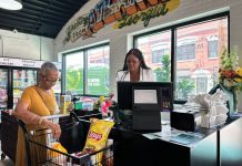 the inside of Goodr Community Market, at the cash register with a shopper buying affordable food