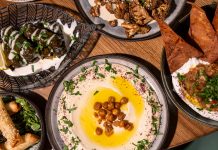 Shared mezze: hummus, cheese cigars, stuffed grape leaves, crispy cauliflower, and smoked eggplant