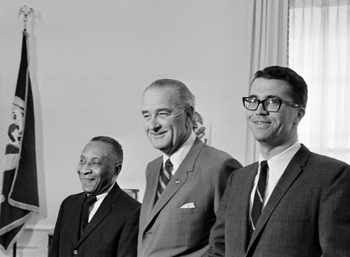 President Lyndon Johnson between White House usher Tom Johnson, left, and deputy press secretary Tom Johnson