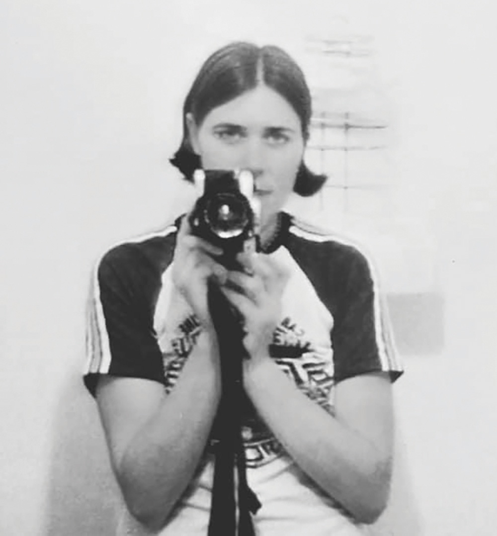 a black and white photo of Katie Janness holidng a film camera