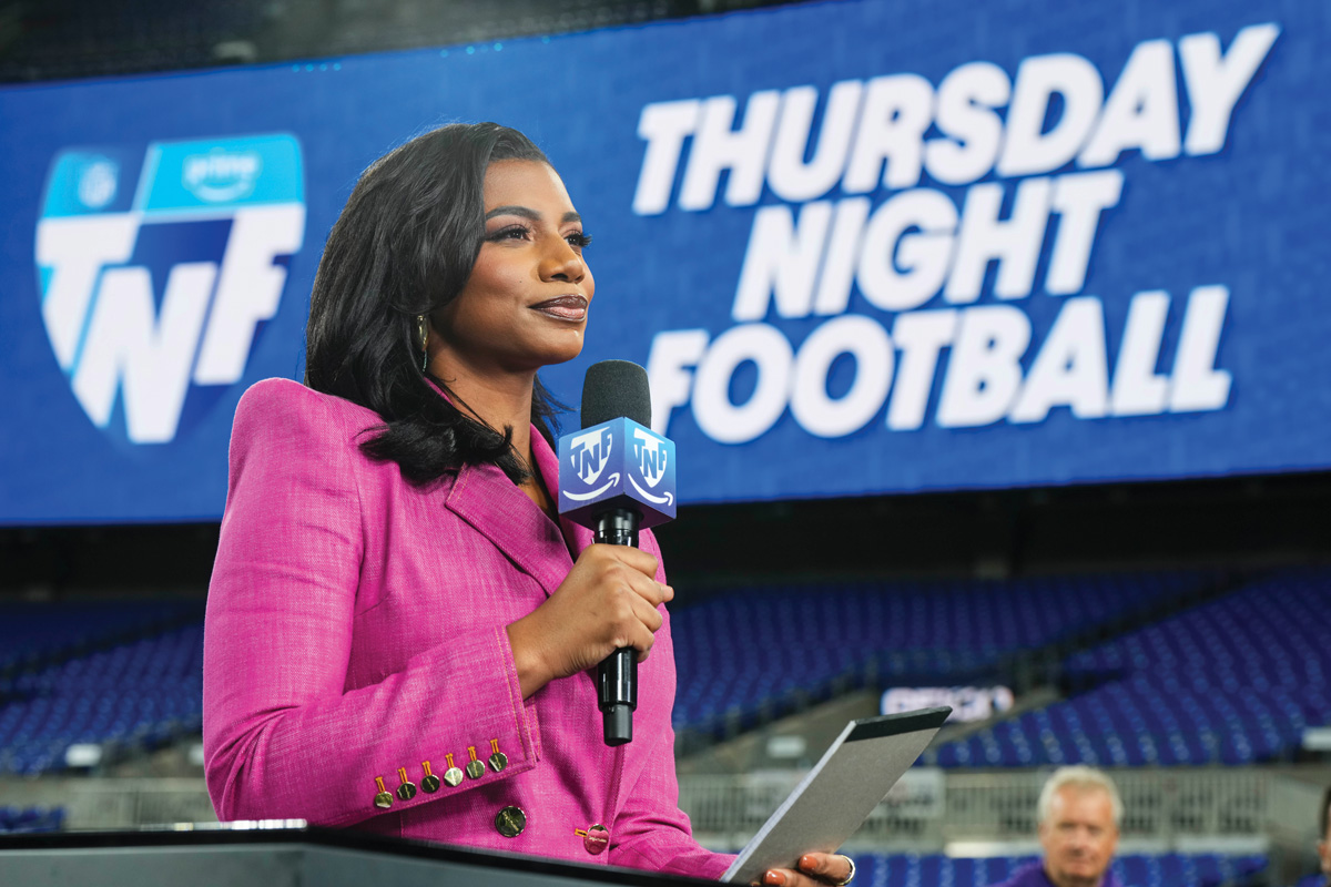 Taylor Rooks in a pink blazer, holding a mic