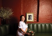 Bar Ana is a Poncey-Highland hideaway with luxe desserts and cocktails pastry chef Claudia Martinez smiles while sitting iat Bar Ana's green seating booths